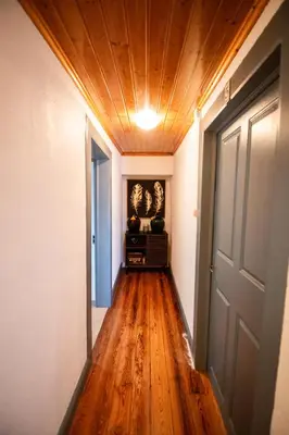 a hallway with a wooden ceiling and a door at Casa das Vistas in Porto Moniz