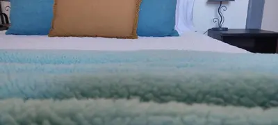 a close up of a bed with blue pillows at Casa das Vistas in Porto Moniz