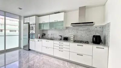 a white kitchen with white cabinets and appliances at Upscale Apartment by LovelyStay in Funchal
