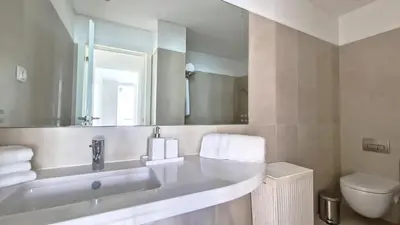 a bathroom with a sink and a toilet and a mirror at Upscale Apartment by LovelyStay in Funchal