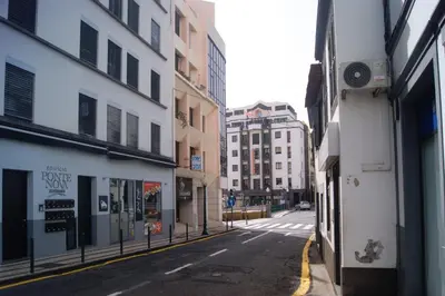 an empty street in a city with tall buildings at Studio no centro do Funchal in Funchal