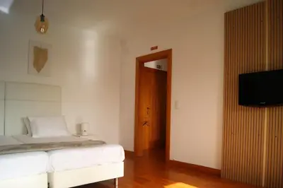 a bedroom with a bed and a flat screen tv at Studio no centro do Funchal in Funchal