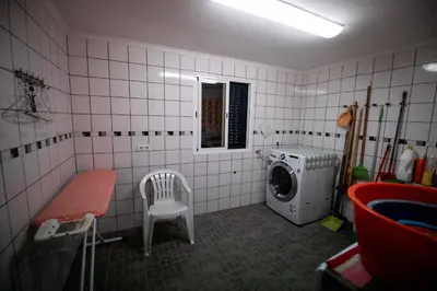 a laundry room with a washing machine and a chair at Casa da Montanha in Salão
