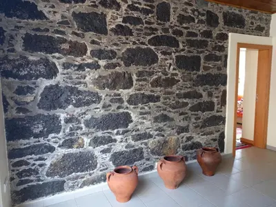 four clay pots lined up against a stone wall at Casa da Montanha in Salão