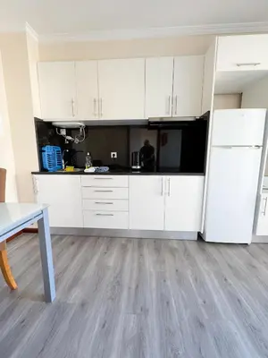 an empty kitchen with white cabinets and a table at LIDO CASA BRANCA in Funchal