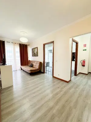 an empty living room with a couch and wooden floors at LIDO CASA BRANCA in Funchal