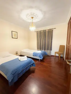 a bedroom with two beds and a chandelier at LIDO CASA BRANCA in Funchal