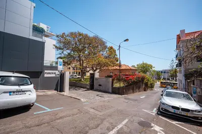 two cars parked in a parking lot on a city street at Jasmineiro Mar - Ocean View Studio in Funchal