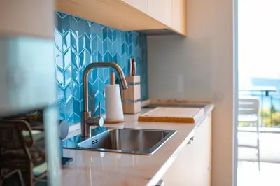 a kitchen with a sink and a blue wall at Jasmineiro Mar - Ocean View Studio in Funchal