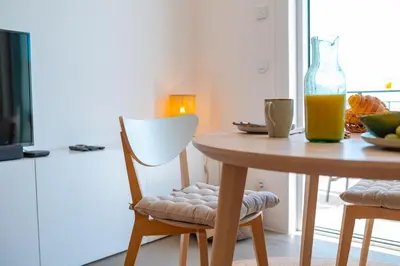 a table with a chair and a vase of orange juice at Jasmineiro Serra - Ocean View Studio in Funchal