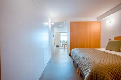 a bedroom with a bed and a wooden wall at Jasmineiro Serra - Ocean View Studio in Funchal