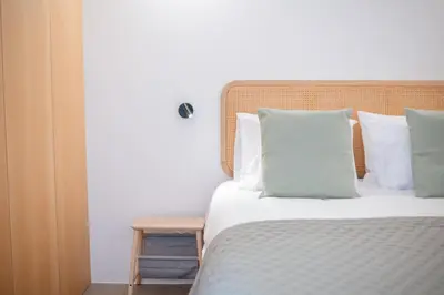 a bed with white sheets and pillows in a room at Jasmineiro Serra - Ocean View Studio in Funchal