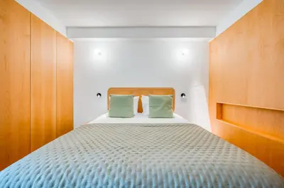 a bedroom with a bed with two green pillows at Jasmineiro Serra - Ocean View Studio in Funchal