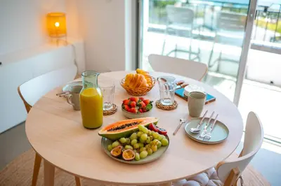 a table with a plate of fruit and juice on it at Jasmineiro Serra - Ocean View Studio in Funchal