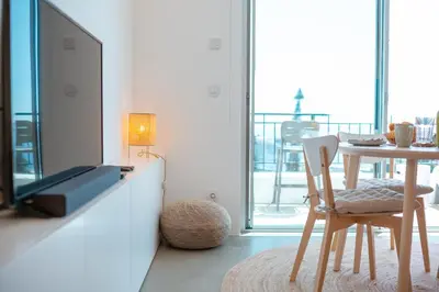 a living room with a tv and a table with a chair at Jasmineiro Serra - Ocean View Studio in Funchal