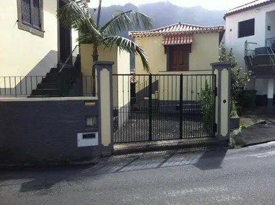 a black fence in front of a house at Mountain View Villa in São Vicente