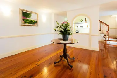 a room with a table with a vase of flowers on it at BIO Hotel - Hotel Quinta da Serra in Estreito de Câmara de Lobos