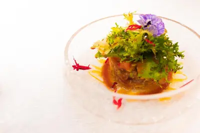 a plate with a dish of food on a table at BIO Hotel - Hotel Quinta da Serra in Estreito de Câmara de Lobos