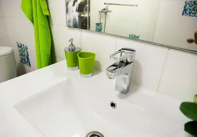 a bathroom sink with two cups and a mirror at Funchal downtown 5min Marina + 2 bedroom + parking in Funchal