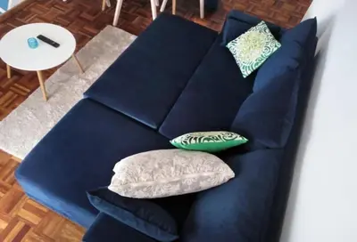 a blue couch with two pillows on it at Funchal downtown 5min Marina + 2 bedroom + parking in Funchal