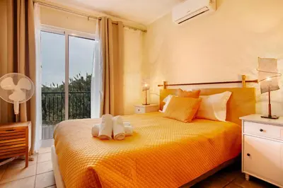 a bed with two pillows and a lamp on it at Energia Dourada - Porto Santo in Porto Santo