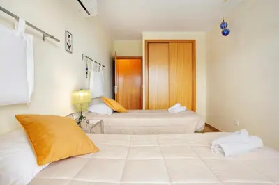 two beds in a hotel room with towels at Energia Dourada - Porto Santo in Porto Santo