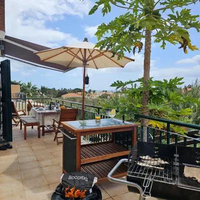 a patio with a table and an umbrella at Energia Dourada - Porto Santo in Porto Santo
