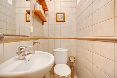a bathroom with a white toilet and a sink at Energia Dourada - Porto Santo in Porto Santo