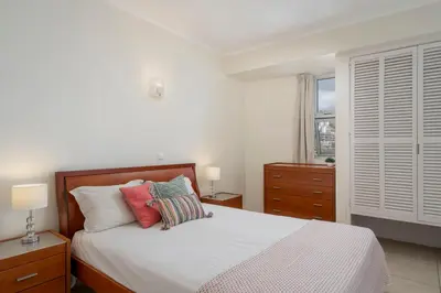 a bedroom with a bed with pillows and a window at Apartamento do Mar II by An Island Apart in Funchal