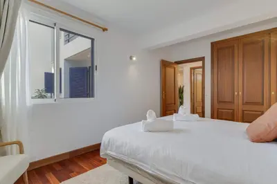 a white bedroom with a large bed and a window at Tropical Pearl by Atlantic Holiday in Funchal