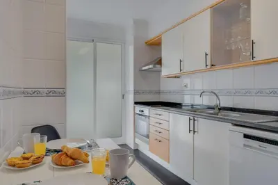 a kitchen with two plates of bread and orange juice at Tropical Pearl by Atlantic Holiday in Funchal