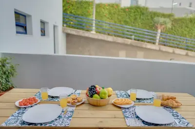 a table with plates of food and a bowl of fruit at Tropical Pearl by Atlantic Holiday in Funchal