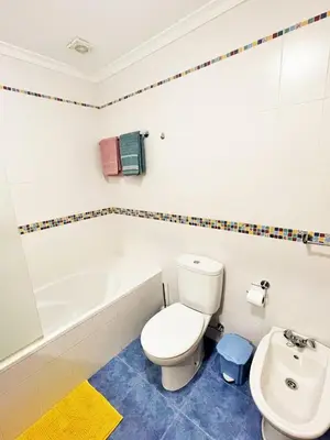 a bathroom with a toilet and a tub and a sink at Lua do Mar in Caniço