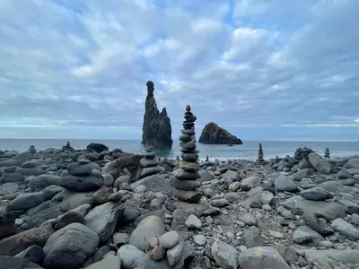 a stack of rocks on a rocky beach at Lua do Mar in Caniço