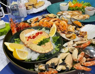 a table topped with plates of food with seafood at Lua do Mar in Caniço