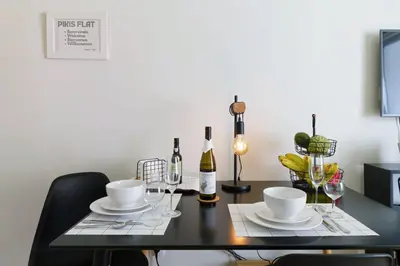 a black table with two cups and plates and wine bottles at Apartamentos do Mar - Pikis Flat in Funchal