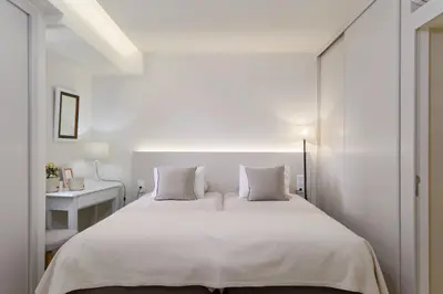 a white bedroom with a large bed with white pillows at Apartamentos do Mar - Pikis Flat in Funchal