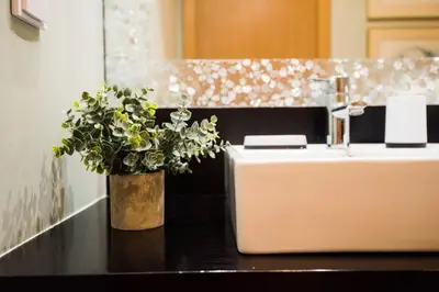 a bathroom sink with a vase of flowers on a counter at Sunrise Apartment in Caniço