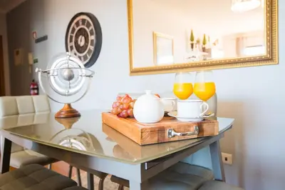 a table with a bowl of fruit and orange juice at Sunrise Apartment in Caniço