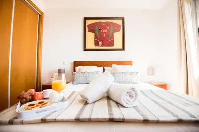 a hotel room with a bed with a tray of food at Sunrise Apartment in Caniço