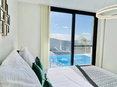 a bedroom with a bed with a view of a pool at Haus am Meer by Your Madeira Rentals in Paul do Mar