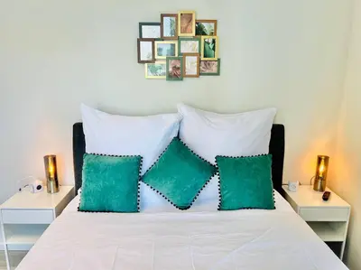 a white bed with two green pillows on it at Haus am Meer by Your Madeira Rentals in Paul do Mar
