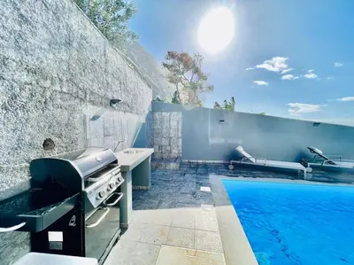 a backyard with a grill and a swimming pool at Haus am Meer by Your Madeira Rentals in Paul do Mar