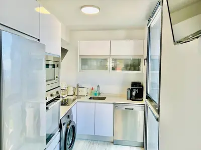a kitchen with white cabinets and a washer at Haus am Meer by Your Madeira Rentals in Paul do Mar