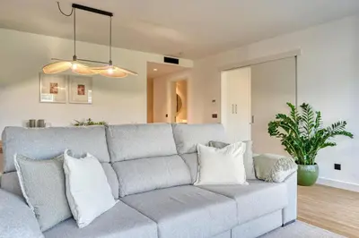 a living room with a gray couch with pillows at São Lucas, a Home in Madeira in Funchal