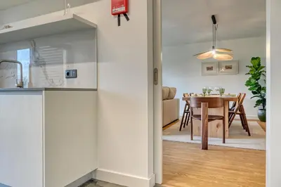 a kitchen and dining room with white walls and a table at São Lucas, a Home in Madeira in Funchal