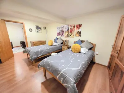 a bedroom with two beds with gray comforters at Near Levadas and Pico Ruivo, Santana Madeira Getaway with Terrace Views in Santana