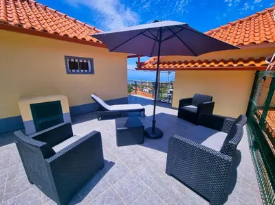 a patio with chairs and a table and an umbrella at Near Levadas and Pico Ruivo, Santana Madeira Getaway with Terrace Views in Santana