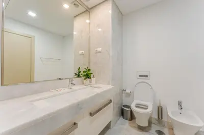 a white bathroom with a sink and a toilet at FLH Madeira Palace Oceanfront Luxury in Funchal