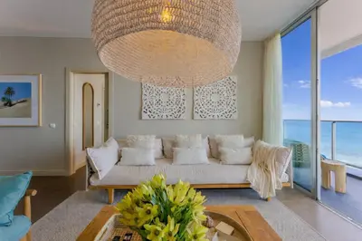 a living room with a white couch and a large chandelier at FLH Madeira Palace Oceanfront Luxury in Funchal